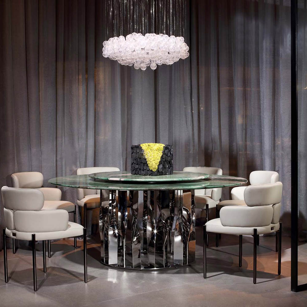 Elegant round green marble table set for fine dining in a modern luxury hotel restaurant interior