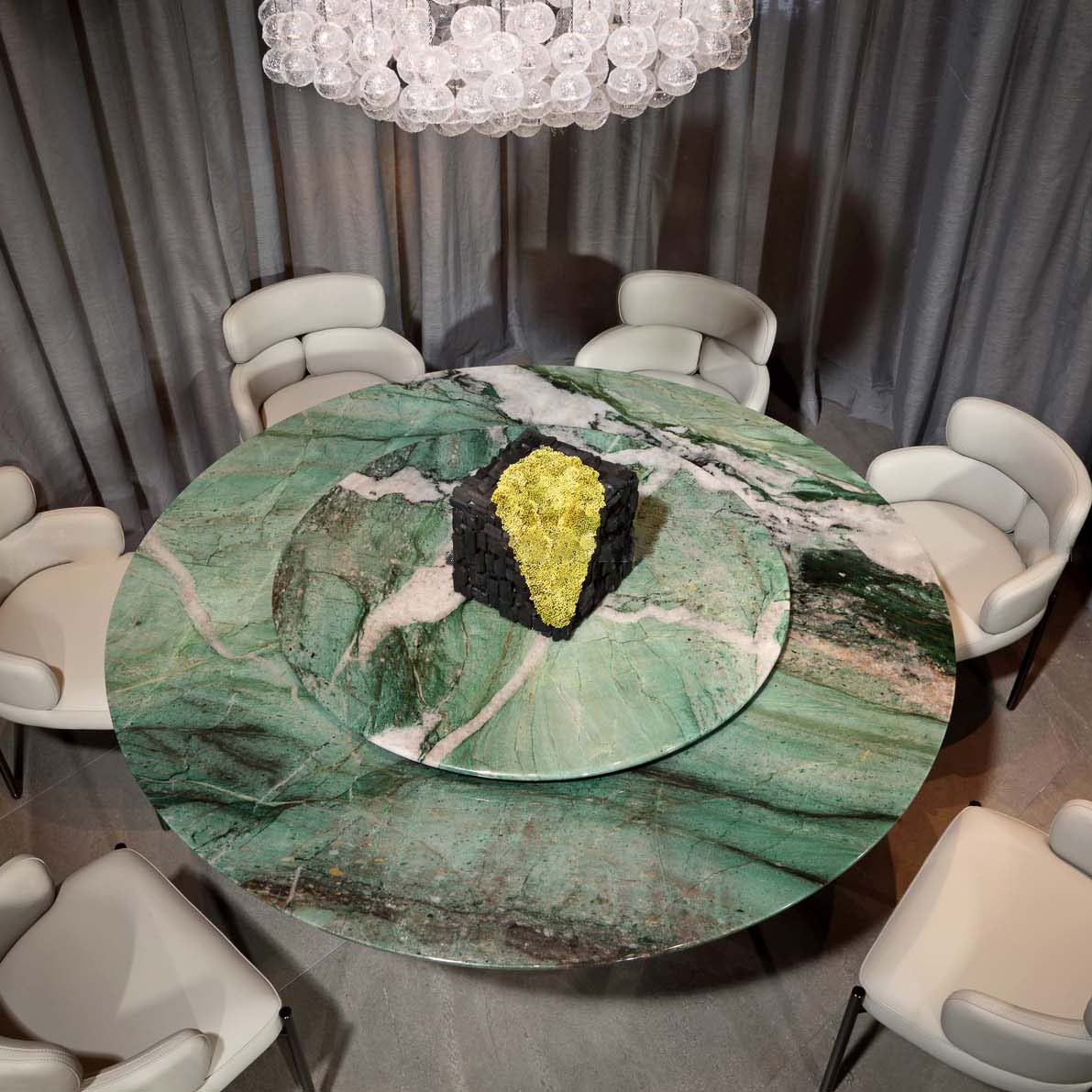 Luxury green marble dining table with Lazy Susan in upscale restaurant setting, surrounded by velvet dining chairs and ambient lighting