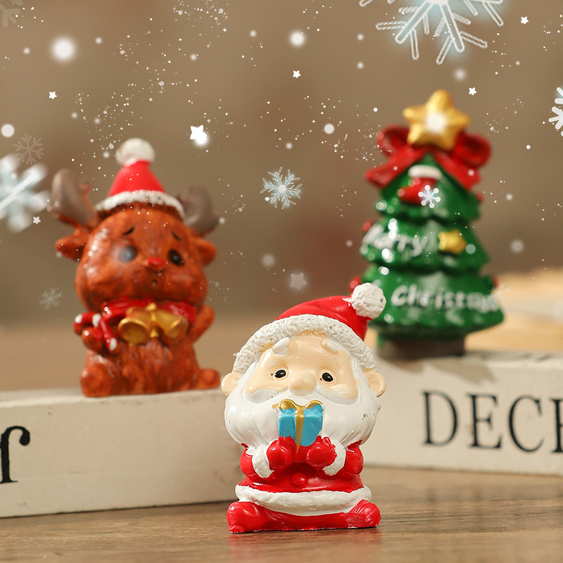 Three-piece resin Christmas ornament set on wooden table