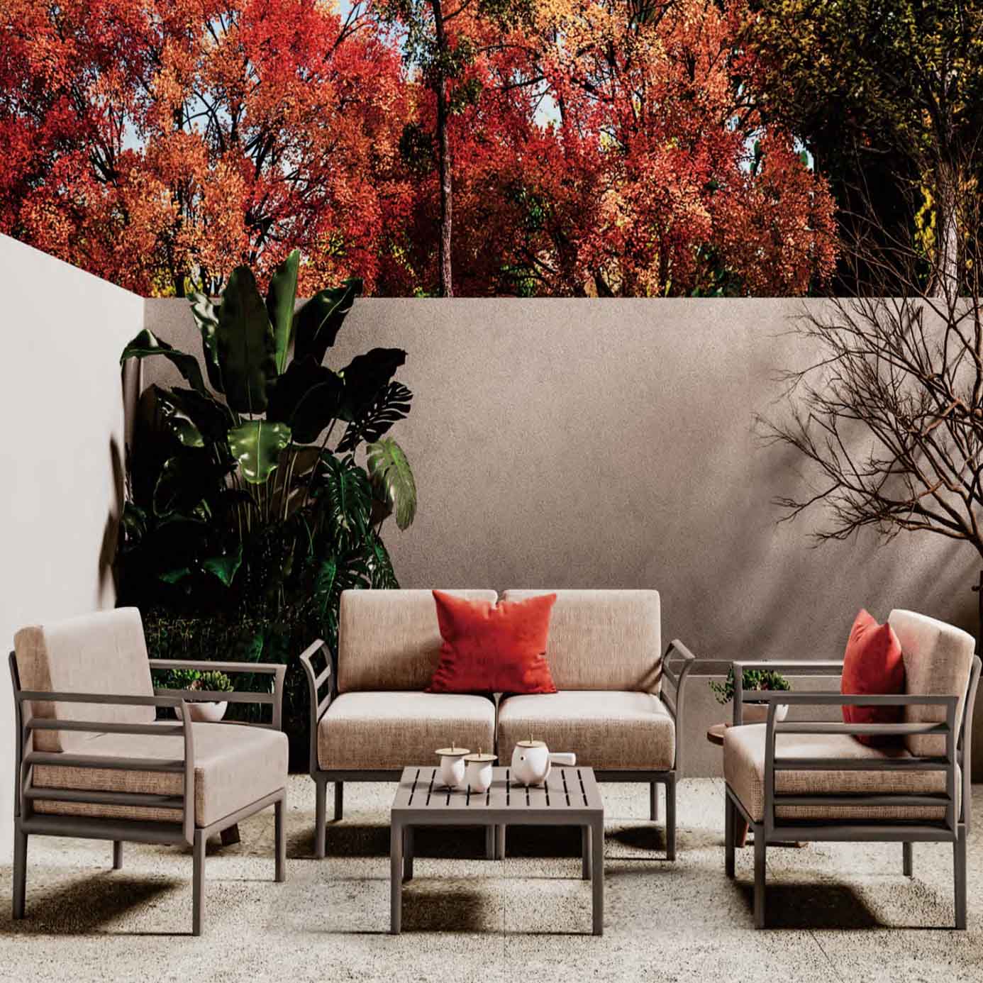 Modern beige outdoor sofa set with red accent pillows, set against autumn foliage backdrop