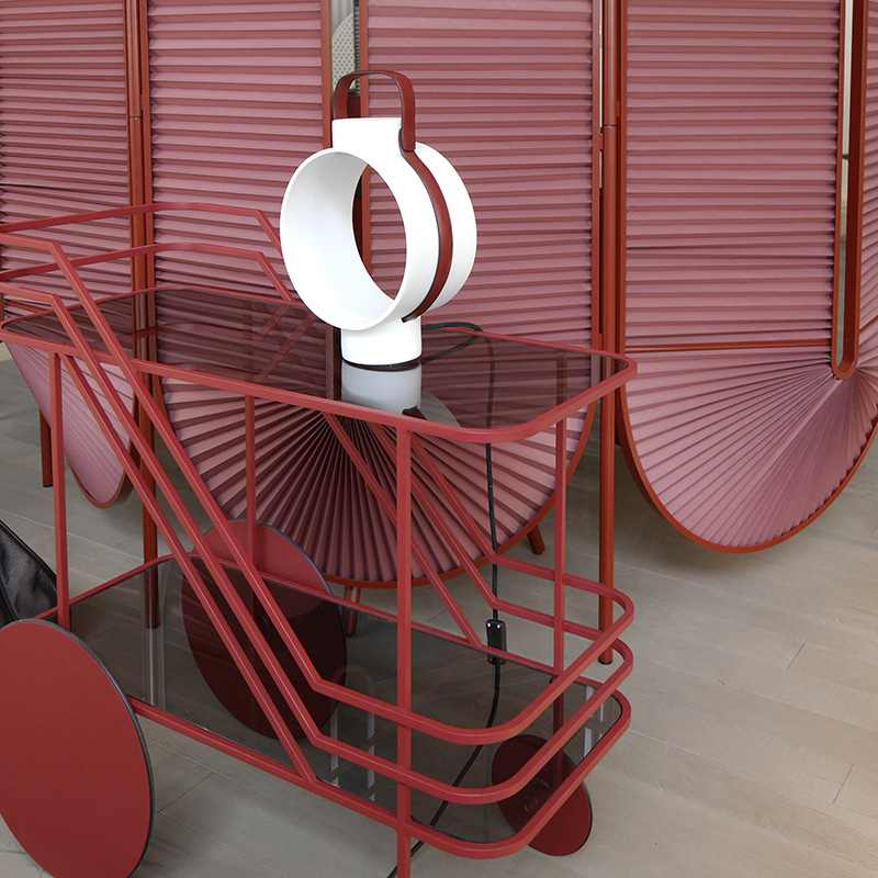 red bar cart's curved metal frame and round wheel design