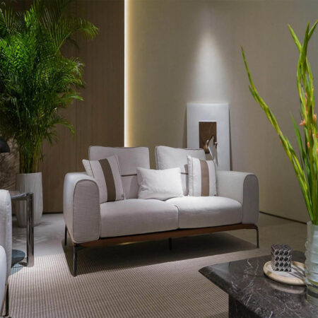 Canapés modulaires italiens haut de gamme dans une salle d'exposition de meubles modernes avec murs en marbre et cloisons en verre.