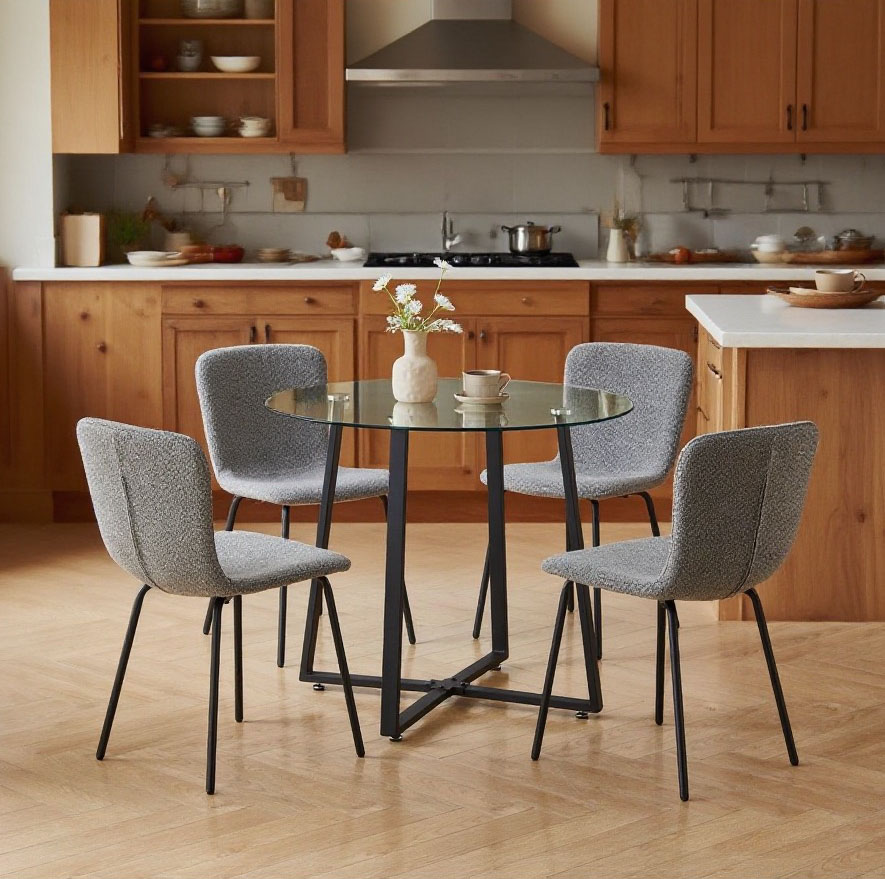 Modern American dining room with a navy blue fabric chair and round glass table, set near a window with natural light and beige walls.