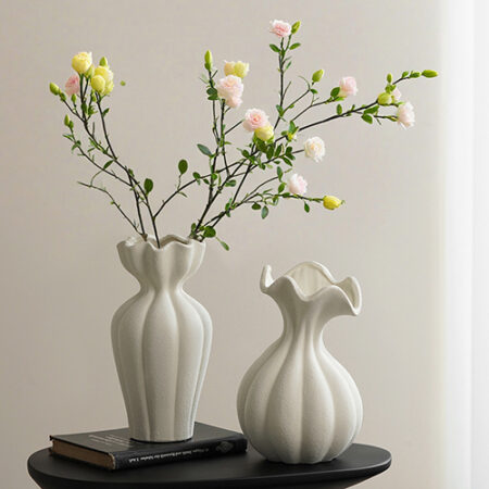 Classic white ceramic flower vases with yellow and green floral branches on black table