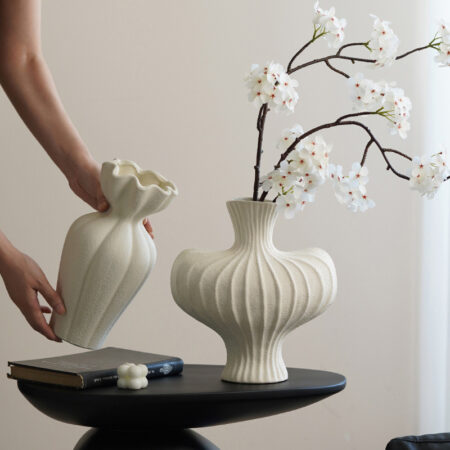 Hand arranging modern ceramic vase with branches, rustic aesthetic home scene